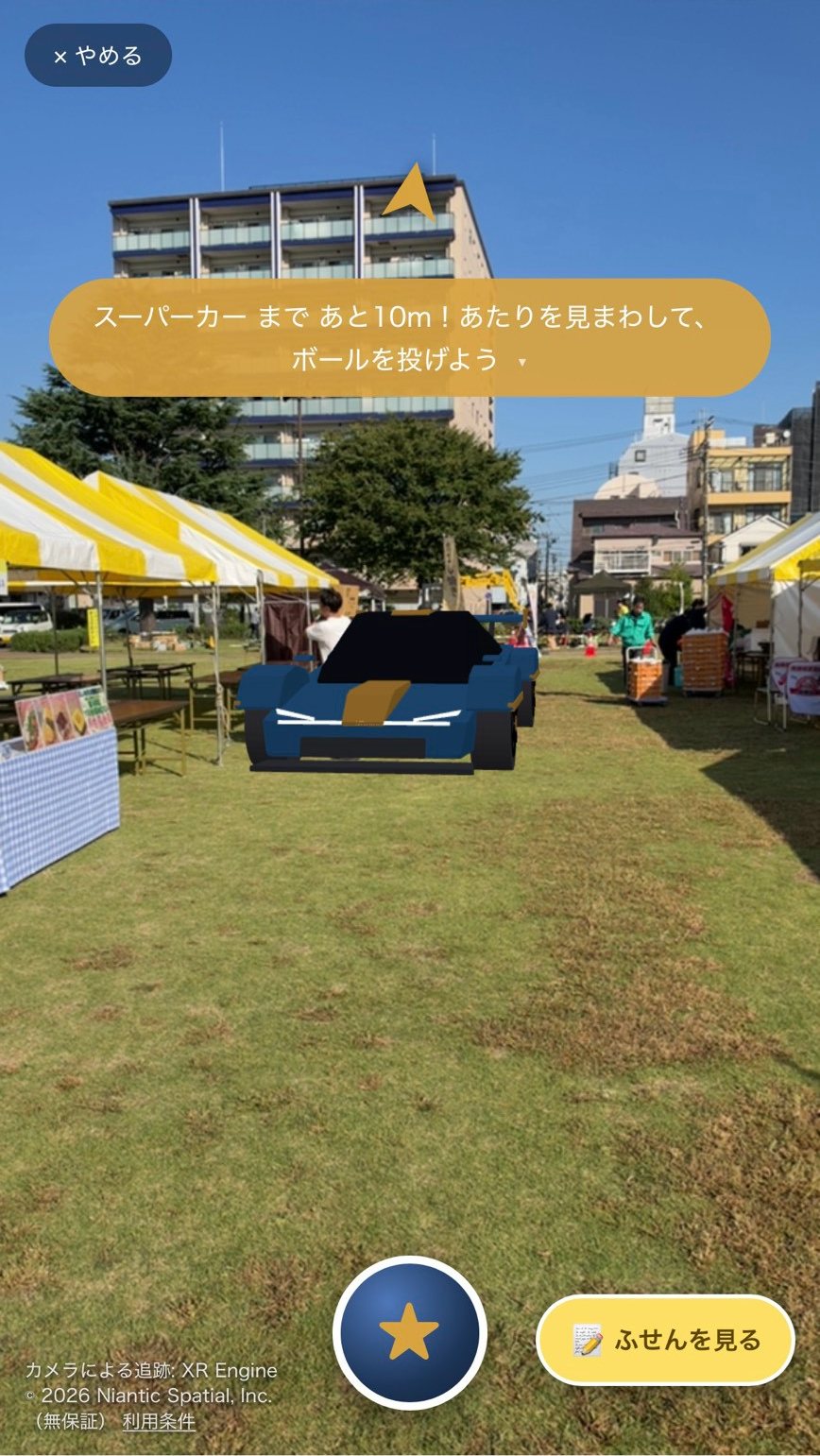 会場の芝生に AR のスーパーカーが現れている